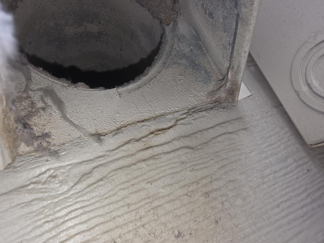 Exterior dryer vent opening packed with lint on a Boulder County home